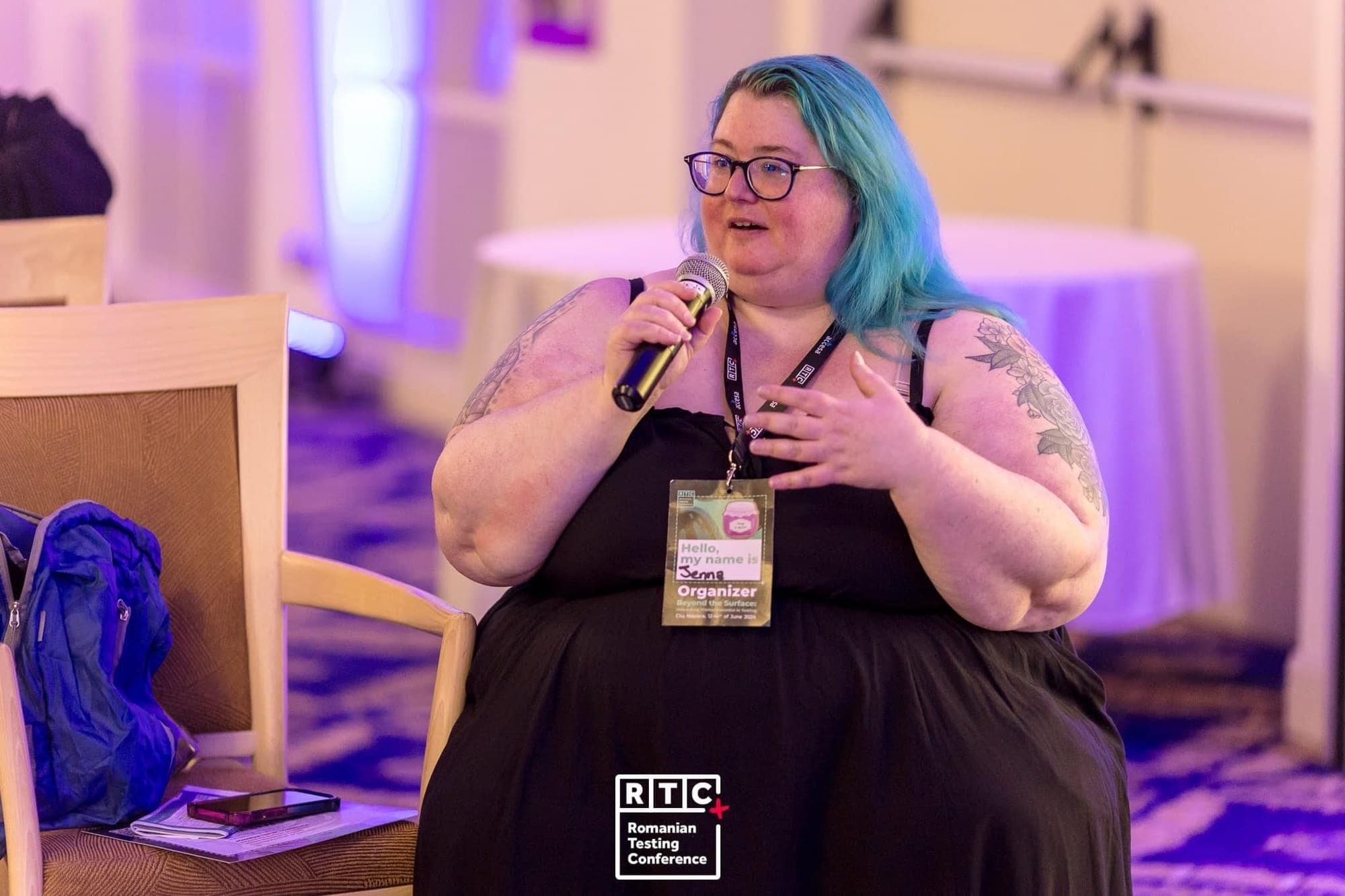Photo of Jenna Charlton in black dress wearing a Romanian Testing Conference badge