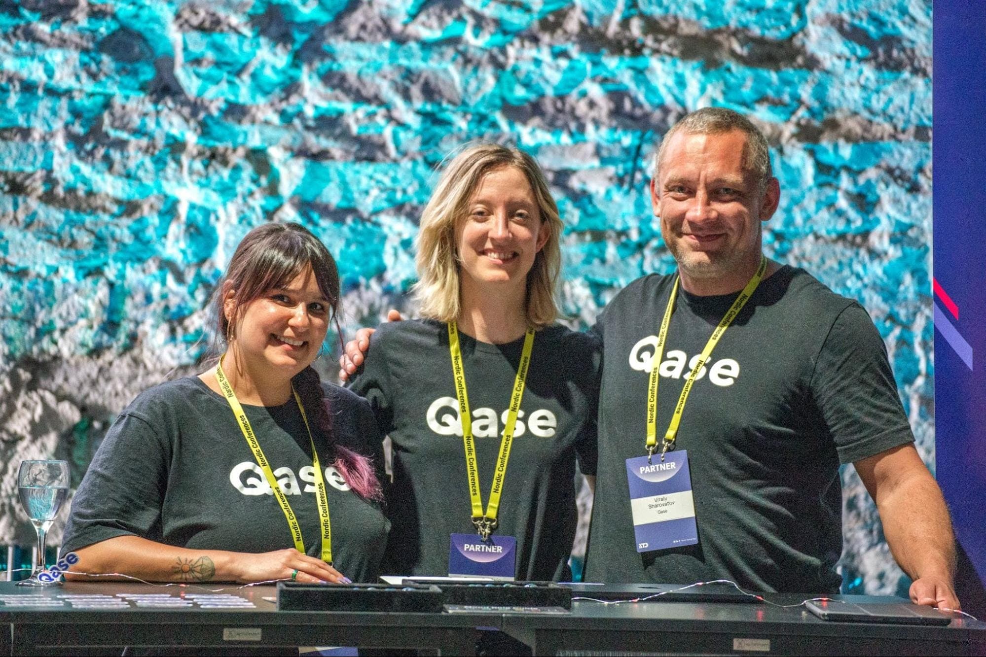 Photo of Rease Rios, Breezy Baldwin, and Vitaly Sharovatov in black Qase t-shirts and Nordic Testing Days badges