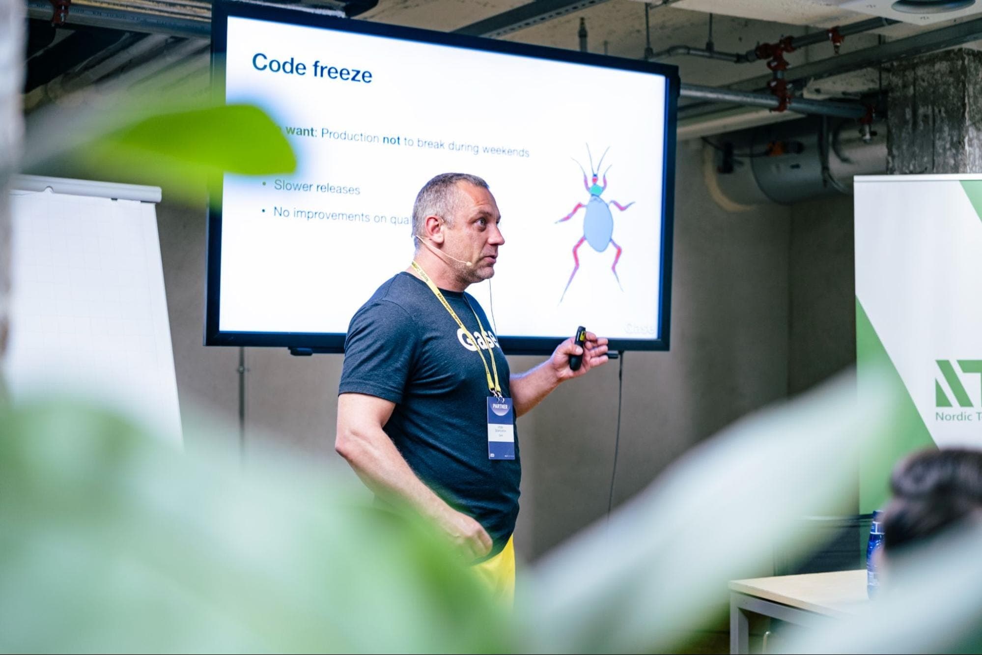 Vitaly in a Qase t-shirt and yellow pants fiving a presentation, current slide titled "Code freeze"