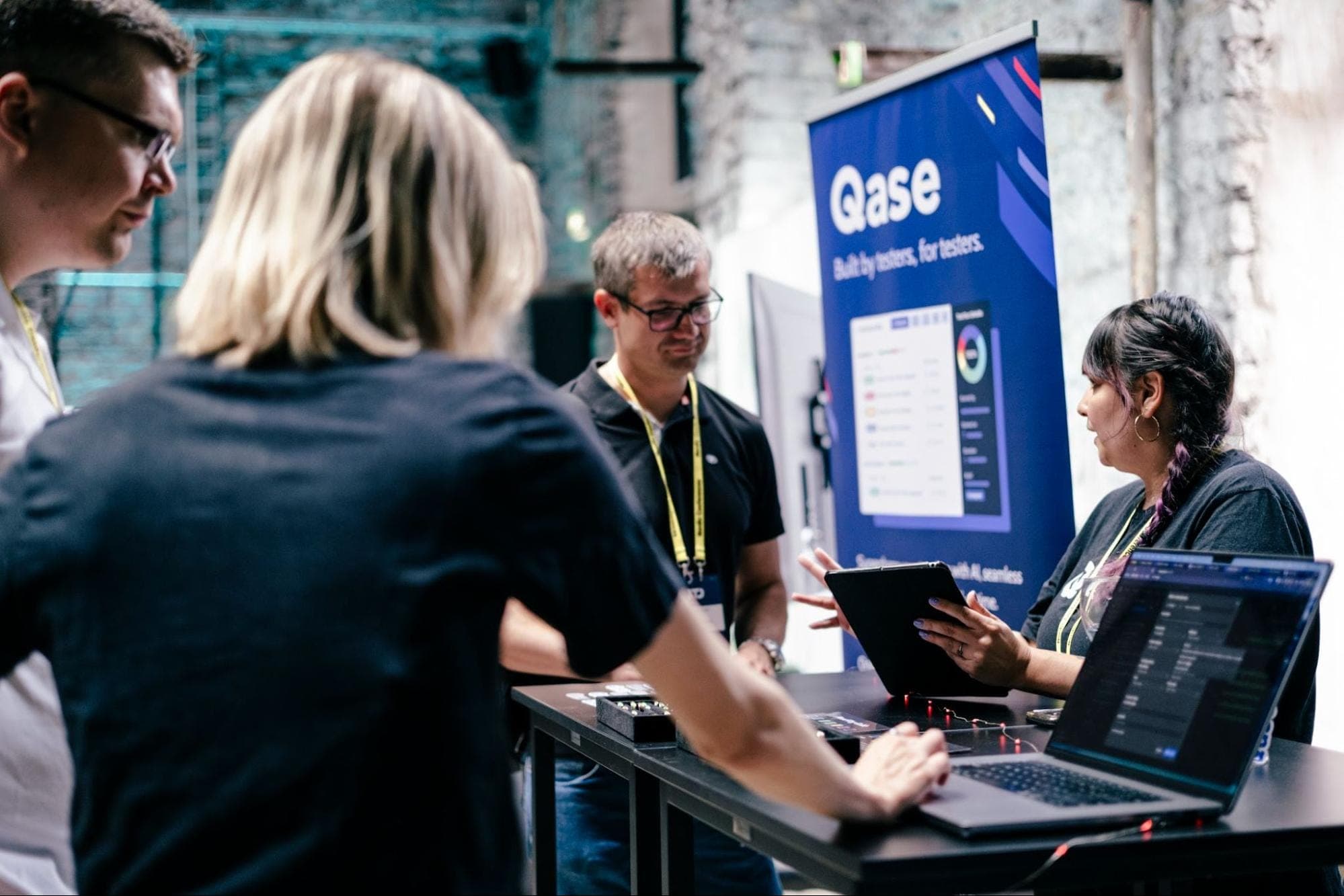 Breezy Baldin and Rease Rios at Qase booth at Nordic Testing Days, demoing Qase to attendees