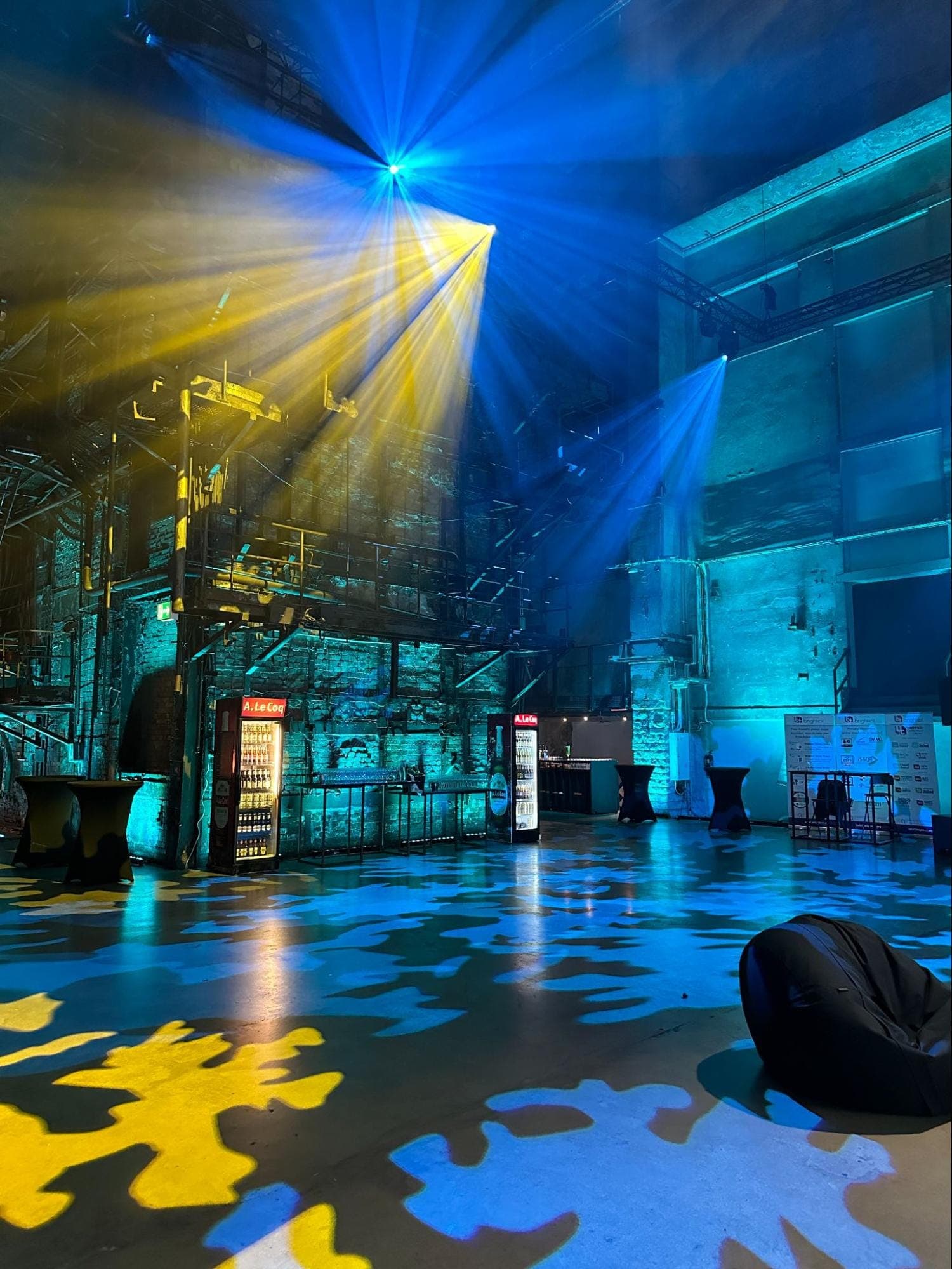 Yellow and blue lights creating puzzle-like piece shapes on the floor in an industrial space